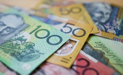 Australian currency piled up going from $100 bill downwards in denominations